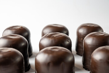 Chocolate covered marshmallow candy on white background