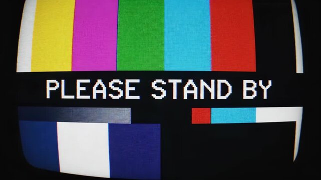 Distorted television screen displaying a please stand by message with colorful test pattern please stand by