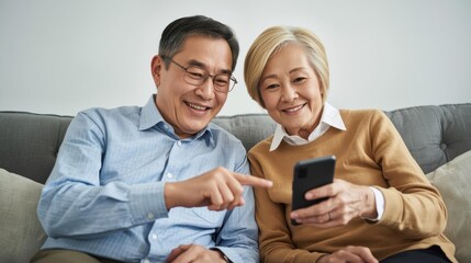 Happy senior couple enjoying time together with smartphone at home