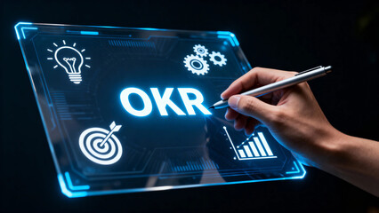 Hand writing OKR on a futuristic digital tablet with icons representing goals, innovation, and analytics