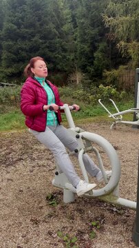 Woman exercising on a fitness machine outdoors