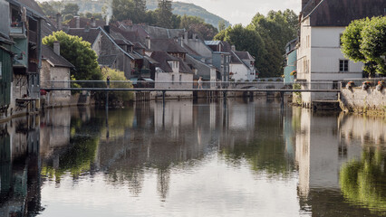 Obraz premium Au cœur de la vallée de la rivière la Loue dans le département du Doubs en France , la ville d' Ornans est un petit joyau aux maisons pittoresques suspendues au-dessus de la rivière