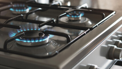 Close-up of a blue fire from a kitchen stove. 4 gas burners with a burning flame. economy concept.