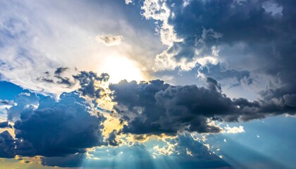 Rays pierce through dark clouds, illuminating the scene with bright beams against a vibrant blue sky backdrop
