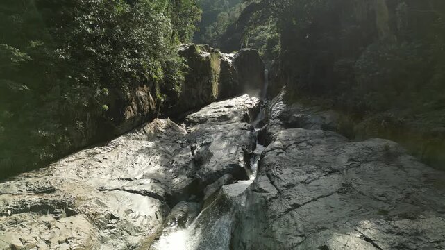 Beautiful top-down drone shot of waterfall stream surrounded by bright tropical green &mdash; perfect for eco-friendly travel content