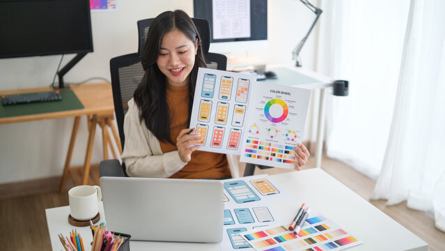 Young woman UX UI designer showing app layout mockups for digital product development.