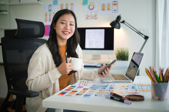 Young UX UI designer enjoying coffee while evaluating app prototype on mobile device. - Powered by Adobe