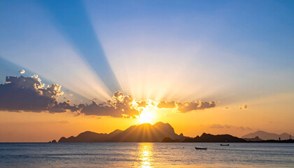 Scenic sunset with sun rays against bright blue sky