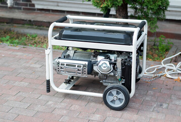 Portable gasoline or diesel power generator with a white frame and wheels standing on a brick patio outdoors.