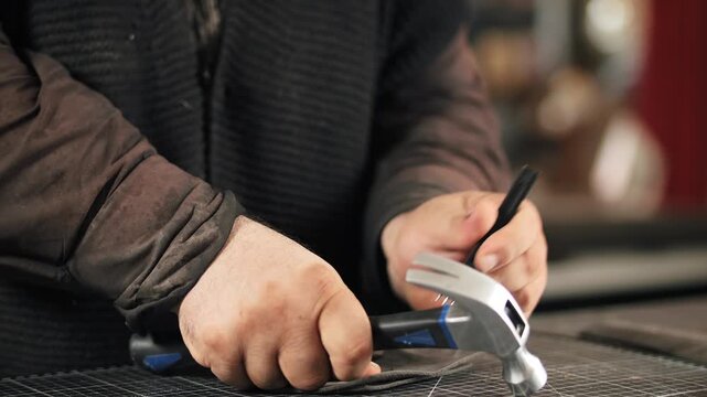 Leatherworker punching holes with hammer and chisel