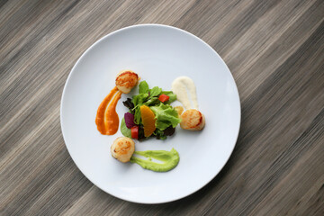 Gourmet plate with perfectly seared scallops arranged artfully on a pristine plate