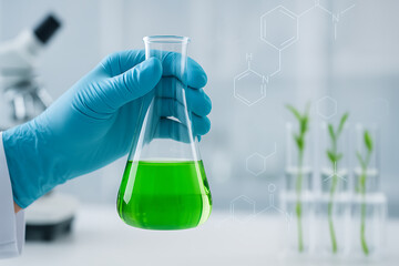 Laboratory research concept with scientist hand holding flask of green liquid symbolizing biotechnology and chemistry