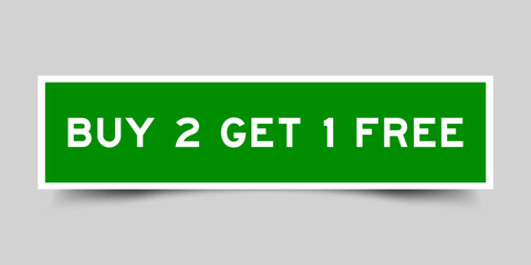 Green color square shape sticker label with word buy 2 get 1 free on gray background