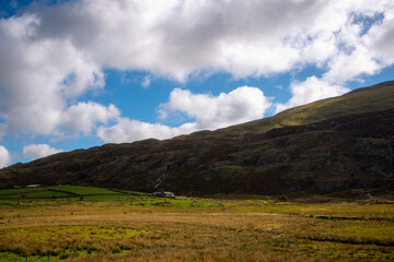 Isolated Farmhouse Beneath Dramatic Clouds in Snowdonia Valley, Wales