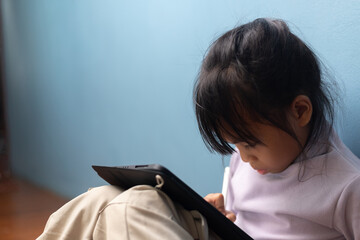 Asian little girl writing on tablet with stylus for creative digital learning at home, concept of smart education, focus, and e-learning technology for children in modern lifestyle.
