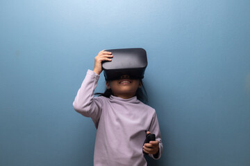 Young girl playing with virtual reality headset experiencing immersive digital world, concept of VR learning, metaverse, and modern technology for children.