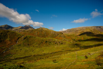 Rolling green hills and Snowdon peaks under clear sky, Snowdonia, Wales