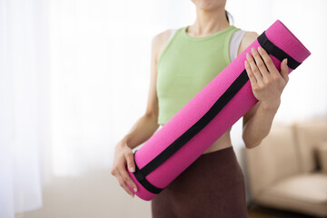 Woman in Activewear Holding Pink Yoga Mat Indoors