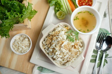 A delicious seafood dish, crab fried rice, served with dipping sauces and fresh vegetables. The composition captures a delightful culinary experience, inviting the viewer to savor the flavors
