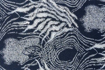 Blue-grey jacquard fabric texture with metallic lurex and abstract wave pattern, part of textile collection