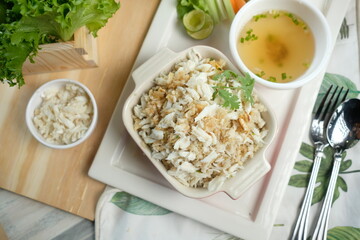 Delicious crab meat and rice dish, garnished with herbs and a side of soup, ready to eat