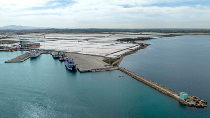 Aerial view of the salt pans located near Trapani, Sicily, Italy. There is a pier for docking ships.