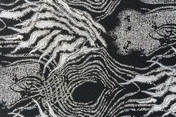 Dark grey jacquard fabric texture with metallic lurex and abstract wave pattern, part of textile collection