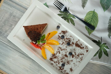 A delicious slice of cake with creative fruit garnish on a plate, ready to be enjoyed