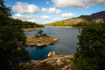 Lake with rocky island and forested hills in Snowdonia, Wales