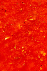 A vibrant, close-up, and abstract background of textured red sauce. The rich color and detailed surface are ideal for culinary, food, and recipe-related designs.