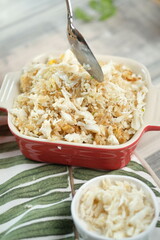 A delectable dish of baked food being served with a spoon