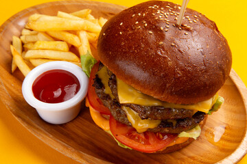 A delicious cheeseburger with fries and sauce.