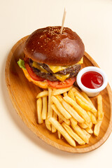 A delicious cheeseburger with fries and sauce.