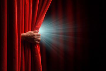 Hand pulls back red velvet curtain to reveal bright light in a dramatic scene