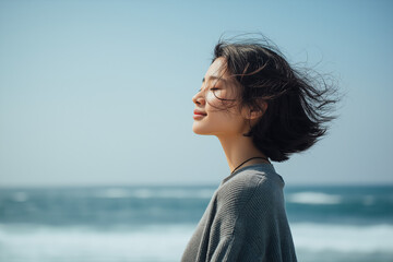 海辺で風を感じる女性