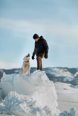 a man with his dog on a snow slide