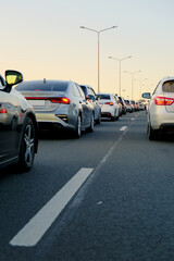 Background, blur, out of focus, bokeh. Rear view from the tail of many cars stuck in line on the highway on a cold cloudy day.
