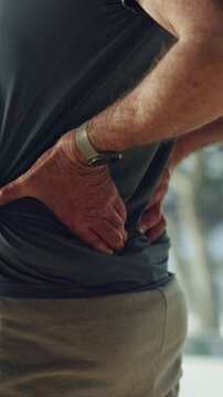 Back pain, injury and hands of old man in home for fibromyalgia, emergency or pressure crisis. Muscle inflammation, osteoarthritis and sprain with senior person in living room of apartment for cramps