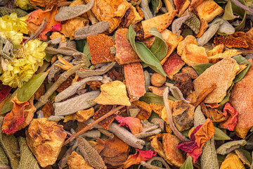Close-up of colorful dried herbs, fruits, and flowers mixture. Showing natural textures and warm tones of potpourri or herbal tea blend. Full frame background of winter tea.