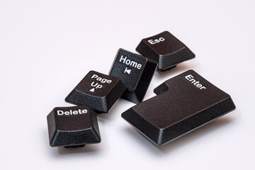 Scattered keyboard keys. “Enter,” “Delete,” “Esc,” “Home,” and “Page Up” placed on a white surface. Symbolizing computing, navigation, control and modern digital communication technology.