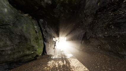 Sunlight breaks into the dark cave, illuminating the rocky entrance. Shadows dance on the ground as nature comes alive in this serene, secluded spot. A sense of adventure fills the air.