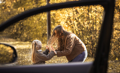 Young mother with child on a rod trip in countryside on the autumn day. Family spending time...