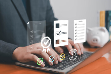Businessman typing on laptop with digital ISO certification icons, checklist, and approval symbols, representing quality assurance, standard compliance, and business process management in technology.