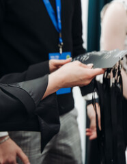 Process of checking in on conference congress forum event, registration desk table, visitors and attendees receiving lanyard with name badge and entry wristband bracelet and register electronic ticket