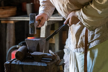 Schmied schmiedet glühendes Metall mit Hammer
