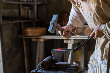 Schmied schmiedet glühendes Metall mit Hammer
