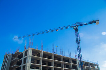 A tall construction crane on a construction site under a bright blue sky, illustrating the city's continued development and architectural progress in a dynamic environment. The concept of building a