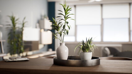 Bright green plants sit gracefully in elegant pots on a smooth wooden table. Sunlight illuminates a cozy living area designed in a minimalistic style.
