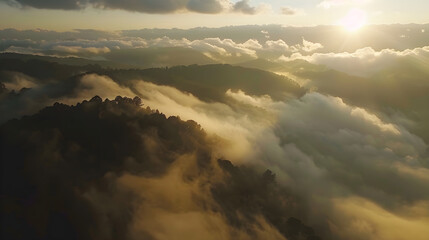 Aerial drone view of mountains at sunrise with golden light. Bird's eye perspective over a sea of clouds and fog. Epic nature landscape for travel and adventure