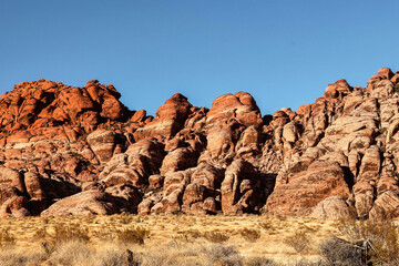 Vibrant Red Sandstone Peaks Rise Majestically Against Azure Skies in Red Rock Canyon's Ancient Desert Embrace, Nevada